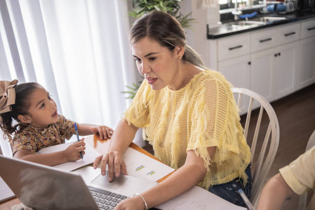 istock Latin mother working and daughter studying at home 1388371618