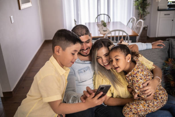 istock Latin family using hte mobile phone at home 1388371701