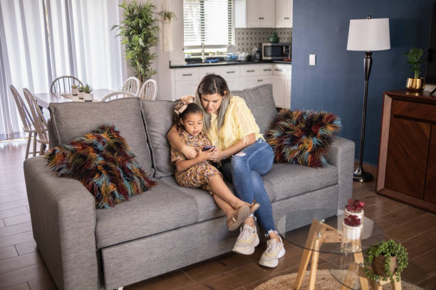 istock Mother and daughter using smartphone at home 1388371728
