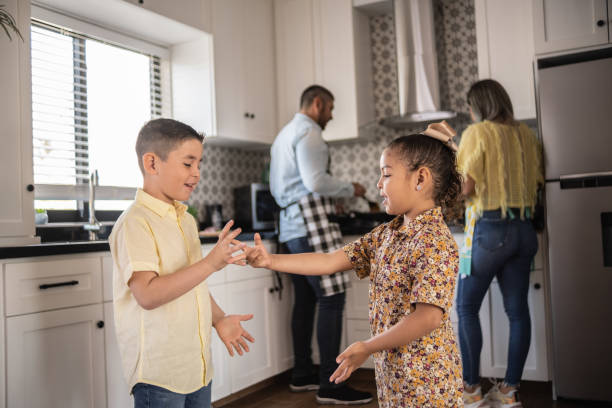 istock Latin siblings playing while parents cook at home 1388371914