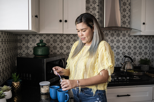 Latin woman preparing coffee at home