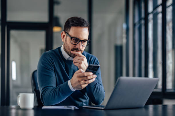istock Focused man, reading something from his mobile phone, looking serious. 1388372916