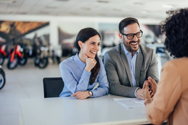 istock Smiling car sales people, talking to their client, giving sugges 1388373152