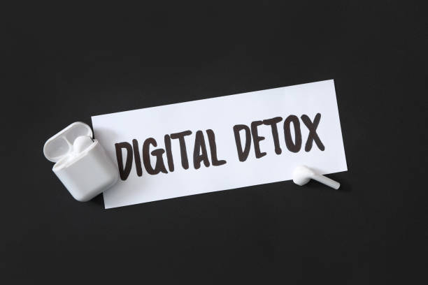 istock Paper note with phrase DIGITAL DETOX and earphones on black background, flat lay 1388373219