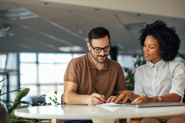 istock Focused people, male and female doing work together, signing con 1388373493