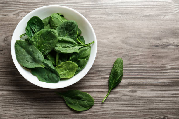 istock Fresh green healthy spinach leaves on wooden table, flat lay. Space for text 1388374967