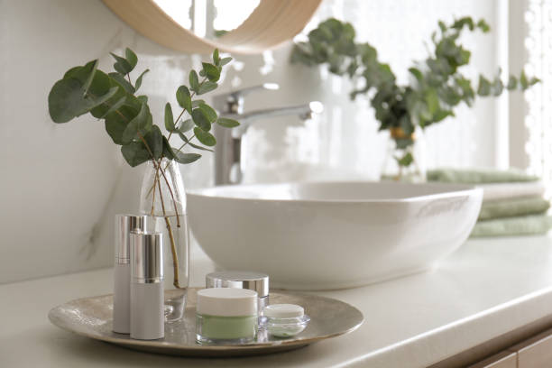 istock Fresh eucalyptus branches and cosmetic products on countertop in bathroom 1388375221
