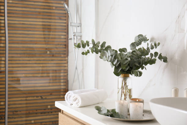istock Fresh eucalyptus branches and burning candles on countertop in bathroom 1388375222