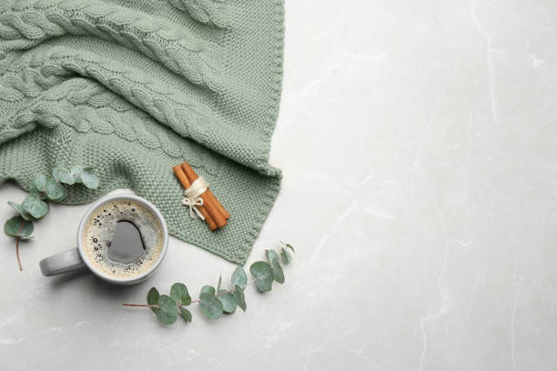 istock Flat lay composition with hot drink and warm plaid on light marble table, space for text 1388375995