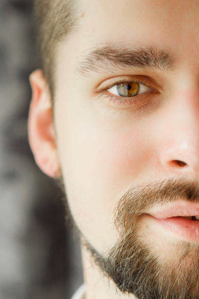 Portrait of a man with a beard. Half face is closed