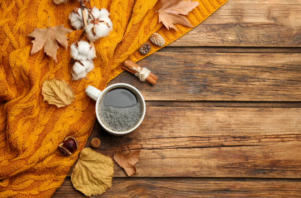 istock Flat lay composition with hot drink and warm plaid on wooden table, space for text 1388376981
