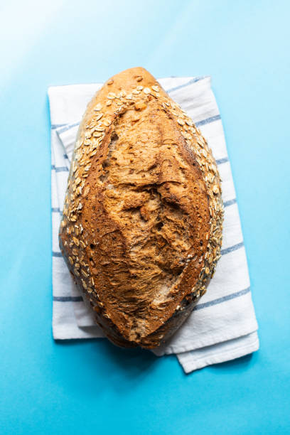 istock Artisanal sourdough bread with oat on a blue background. Top view. 1388377133