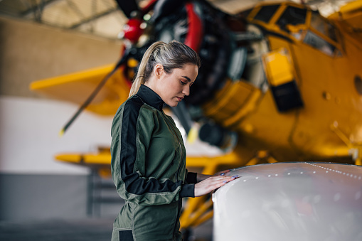 Side profile of a young blonde pilot, checking something.