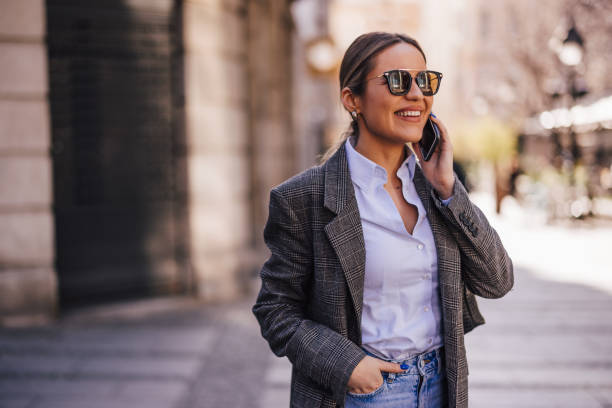 istock Smiling girl, making a phone call while waiting for someone outside. 1388377439