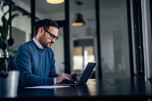 istock Side profile of a businessman, looking focused, working online. 1388379728