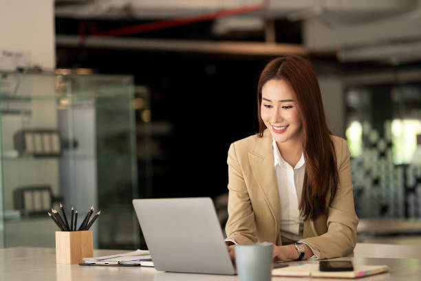 istock Asian businesswoman working with tiger skins notebooks graphs documents at modern desks using computers successful female e-commerce online marketing business accounting business concept 1388379757
