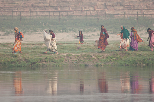 Indian women walking along a riverside. Yamuna River. Agra. Uttar Pradesh. India.