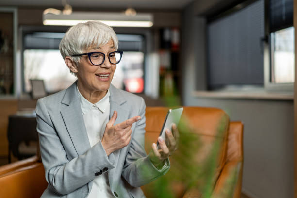 istock Senior businesswoman using mobile phone in the office. 1388381165