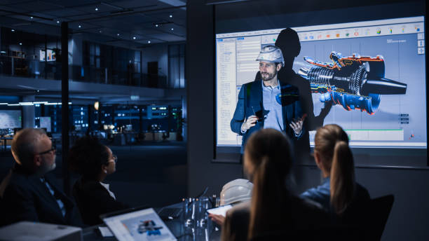 istock Green Energy Technology Conference Presentation: Chief Automotive Engineer Presents Sustainable Environmental Engine Design to Investors and Businesspeople. Screen Shows 3D Model of Electirc Turbine 1388386304