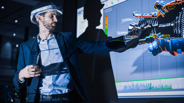 istock Green Energy Technology Conference Presentation: Chief Automotive Engineer Presents Sustainable Environmental Engine Design to Investors and Businesspeople. Screen Shows 3D Model of Electirc Turbine 1388386419