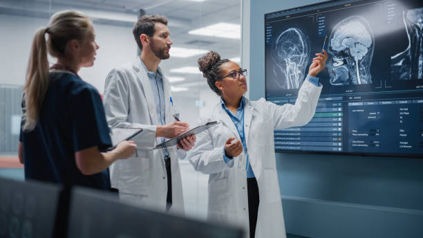 medical science hospital lab meeting: vielfältiges team von neurologen, neurowissenschaftlern, neurochirurgen consult tv-bildschirm mit mrt-scan mit gehirnbildern, gespräch über behandlungsmethode, heilung neuer medikamente - medizinisches scannen stock-fotos und bilder