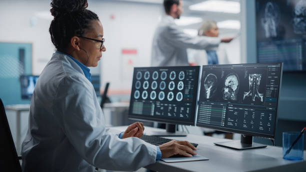医学病院研究研究室:脳スキャンmri画像を備えたコンピュータを使用した黒人女性神経科学者は、病気の患者のための最良の治療法を見つける。ctスキャンをアナリッシングするヘルスケア神� - 脳外科手術 ストックフォトと画像
