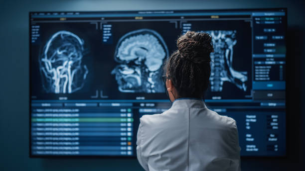 laboratorium badawcze szpitala medycznego: czarna neurobiolog patrząca na ekran telewizora, analizująca obrazy mri skanu mózgu, znajdująca leczenie dla pacjenta. neurolog opieki zdrowotnej leczy ludzi. widok wstecz zoom - mri scan obrazy zdjęcia i obrazy z banku zdjęć