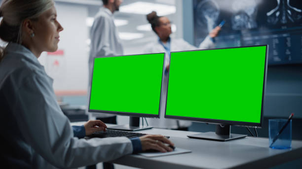 hospital research lab: wissenschaftlerin der medizinischen biotechnologie arbeitet am green screen chroma key computer mit brain scan mrt-bildern. hintergrund: neurowissenschaftler treffen sich bei der analyse des mrt-scans - computer lab green office computer stock-fotos und bilder