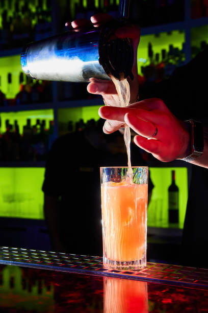 istock The bartender makes the cocktail pours it into a glass standing on the bar 1388387957