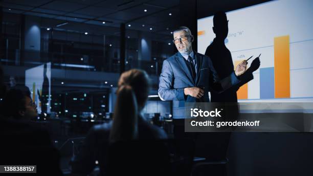 Conference Business Meeting Presentation Chief Executive Officer Shows Data To Diverse Group Of Investors Businessspeople Projector Screen Shows Graphs Product Sales Growth Ecommerce Analysis Stock Photo - Download Image Now