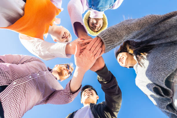 istock Young people joining their palms in a circle and showing unity and support 1388388704