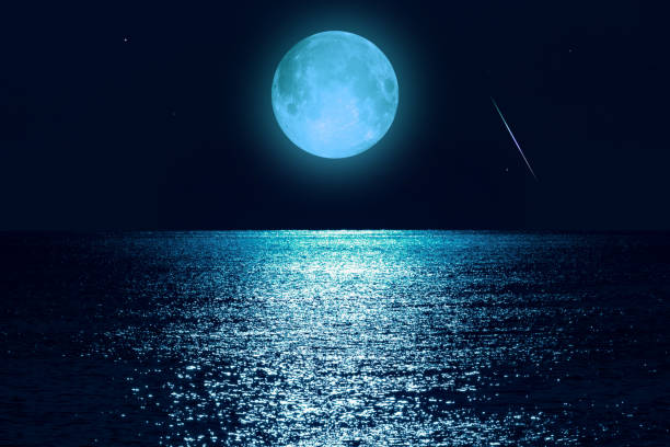 istock Moon with starry skies above ocean horizon. 1388389547