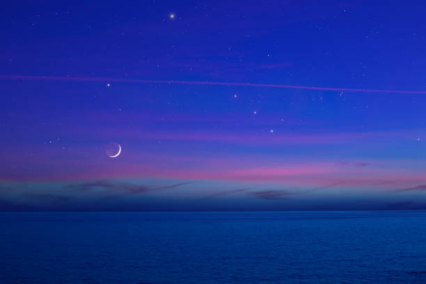 istock Moon with starry skies and planets above ocean horizon. 1388389571