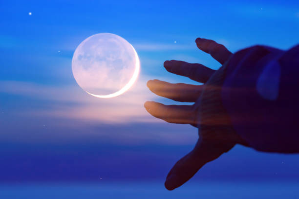 istock Woman's hand under starry, Moonlit night above the ocean waters. 1388390329