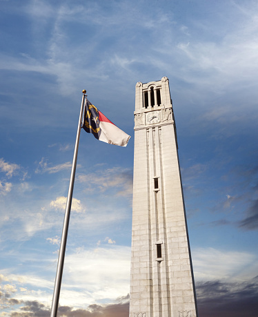 The bell tower and NC state flag on the campus of NC State University in Raleigh North Carolina