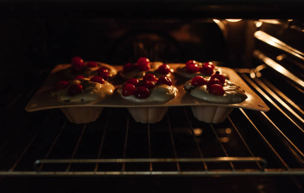 istock The process of baking cupcakes in the oven. Dough for baking cupcakes with cherries. 1388390726