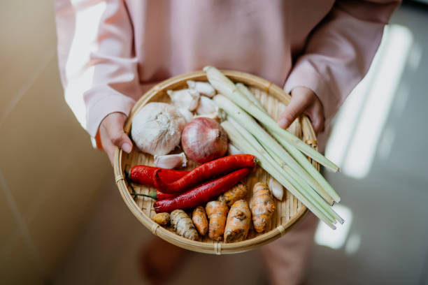 młody malajski chłopiec niosący tradycyjne przyprawy do gotowania malajskich potraw - asian cuisine close up garlic vegetable zdjęcia i obrazy z banku zdjęć