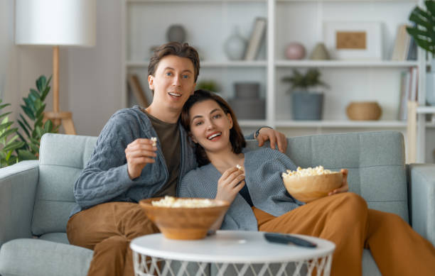 istock couple with popcorn sitting on sofa 1388392056