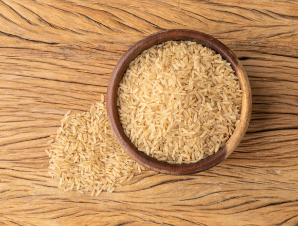 istock Raw brown whole rice in a bowl over wooden table 1388394699
