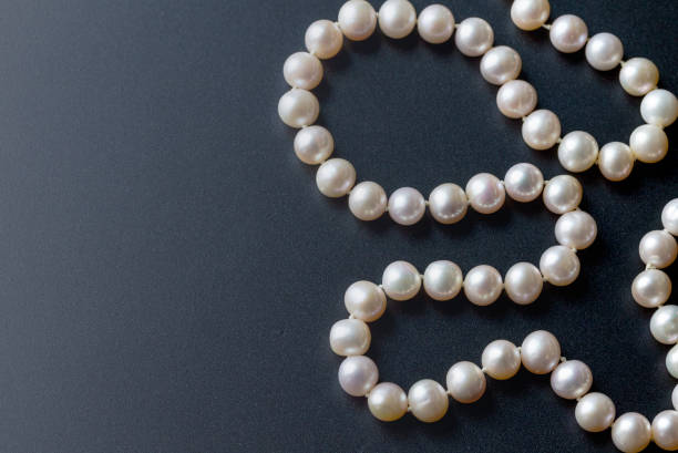 istock Luxury white pearl necklace on a black background with space for text 1388395392