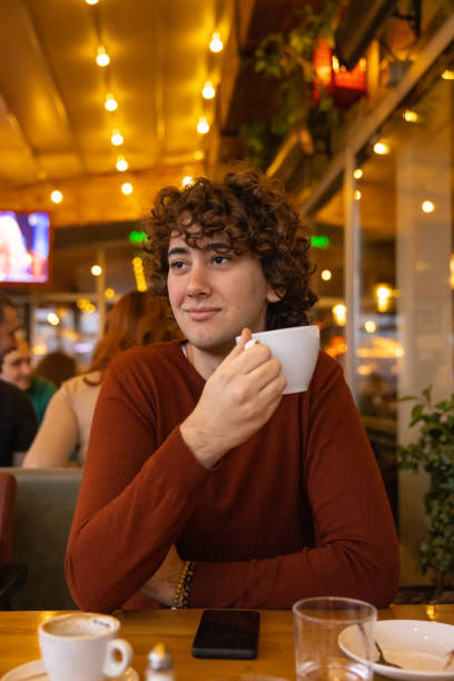 istock Curly hair young man enjoying coffee 1388396204