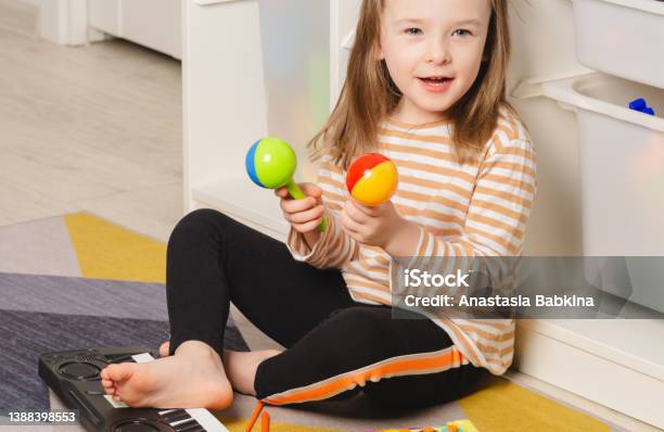 Child Playing Maracas At Home Child Portrait Looking To The Side Stock Photo - Download Image Now