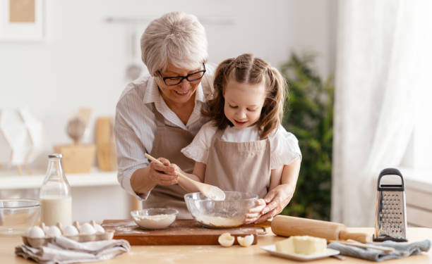 rodzina wspólnie przygotowuje piekarnię - grandmother pie cooking baking zdjęcia i obrazy z banku zdjęć