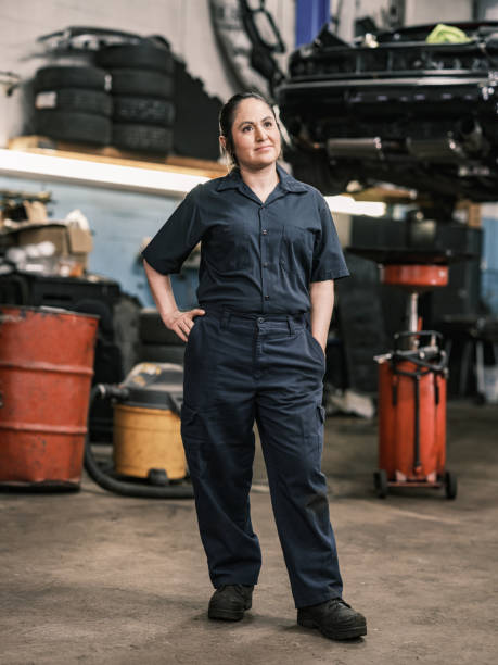 Mexican female mechanic in her shop Mexican female mechanic in her shop. Mid adult woman with braided hair, wearing work clothes. Interior of car and motorcycle repair shop during day. short weave hairstyles stock pictures, royalty-free photos & images