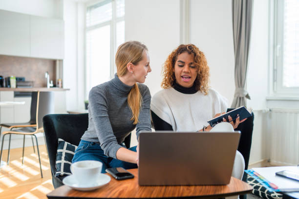 istock Two Friends Using Laptop at Home 1388399956