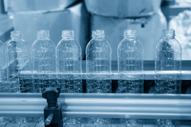 The empty PET bottles  on the conveyor belt for filling process in the drinking water factory. stock photo