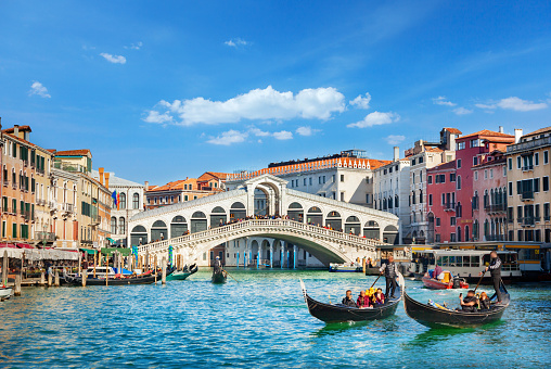 Venice, Italy - July, 12 2023: Stock photo showing close-up view of a row of moored gondola boats at waterfront in Venice, Italy.