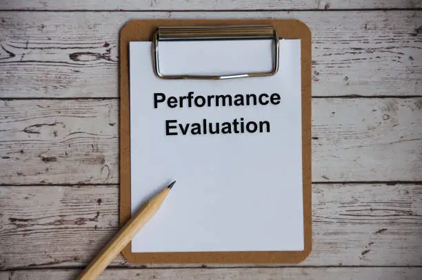 Photo of Top view of performance evaluation text on notepad. Appraisal concept