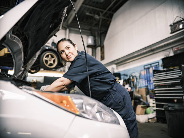 Mexican female mechanic in her shop Mexican female mechanic in her shop. Mid adult woman with braided hair, wearing work clothes. Interior of car and motorcycle repair shop during day. short weave hairstyles stock pictures, royalty-free photos & images