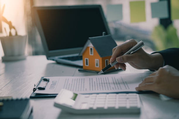 istock A businessman or home sales representative works in the office with contract documents and calculators to calculate interest, taxes, and profit. 1388403626